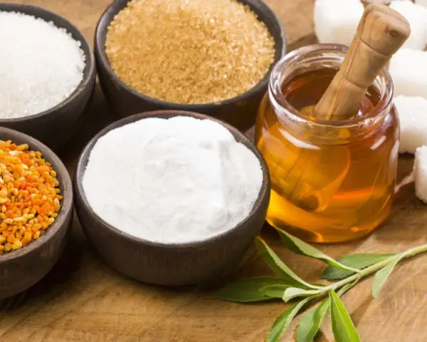 Schalen mit Zucker, Honig, Pollen und Stevia-Blättern – ideale Zutaten für zuckerersatz zum Backen.